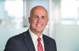 Headshot of Commerce Trust's Paul Lewis in a navy suit with a red tie