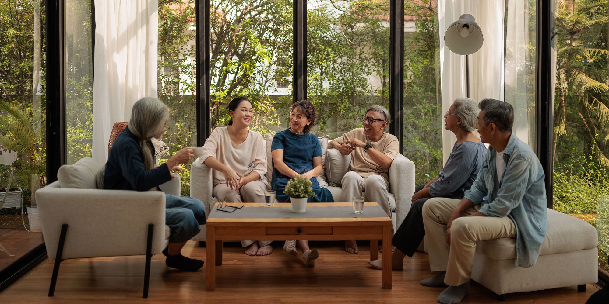 Multi-generational family sitting and talking in sunroom