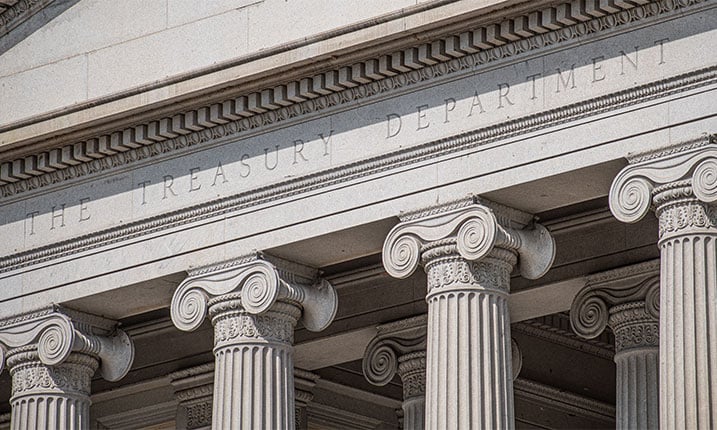 Close up view of the United States Treasury Department building with regal columns and stonework.
