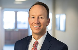 Headshot of Commerce Trust's Michael Fowler in a navy suit with a red tie